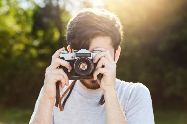 Doğanın güzel manzaralar yeşil alan dinlenme süre çekim fotoğrafları retro kamera ile yapma genç yaratıcı fotoğrafçı. Retro Vintage film kamerası yeşil yaz alanını kullanarak erkek