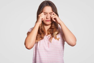 Fotoğraf memnun genç kızın gözleri, düşük ruhu içinde olmak losyonları, Aile içi rahat kıyafetler giyer, beyaz arka planı teşkil etmektedir. Kadın geceleri kötü uyku vardı. Odada mevcut yataklar kullanılıyorsa kavramı. İnsanlar ve yorgunluk