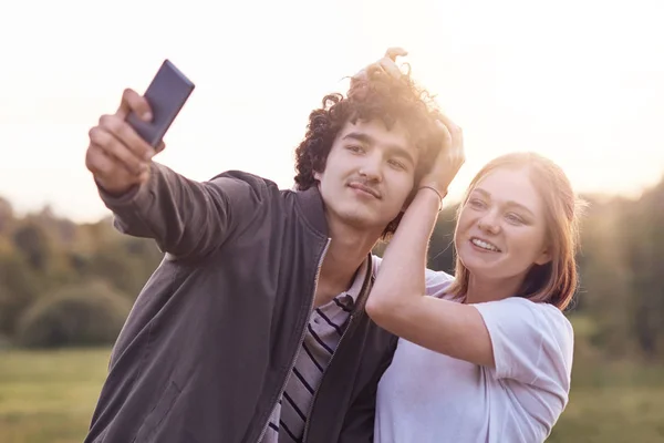 Komik Kıvırcık Erkek Genç Bulanık Doğa Arka Plan Karşı Selfie — Stok fotoğraf