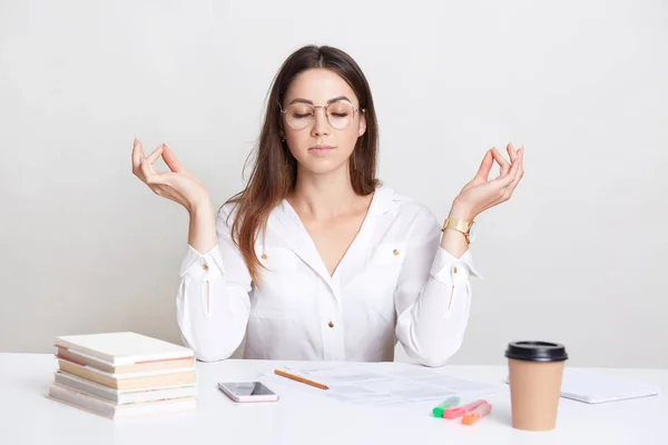 People Spirituality Concept Relaxed Brunette Young Woman Poses Workplace Mudra — Stock Photo, Image