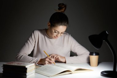 Sınav, defter, kitap yeniden yazar bilgileri için ciddi kadın cramms kapalı atış saç düğüm vardır, transprent gözlük, süreci eğitim dahil takar. İnsanlar, öğrenme ve çalışma kavramı