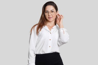 Görüntü hoş giymiş siyah beyaz elbise, büyük yuvarlak gözlük, hazır kadın Tasarımcısı için meslektaşları, onun fikirlerini sunmak isteyen beyaz arka plan üzerinde izole. Kadın yönetmen pozlar kapalı