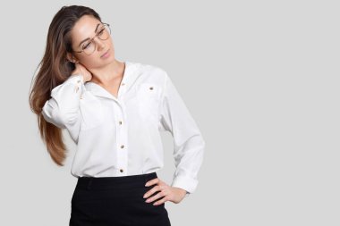 Düşünceli güzel Sekreteri, bir yandan bel üzerinde tutar, beyaz bluz, siyah etek giymiş, yeni projeler hakkında düşünüyor, sol tarafta boş alan ile stüdyo duvara reklam için standları