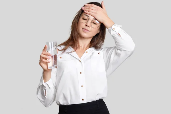 Mulher Cansada Sobrecarregada Mantém Mão Testa Usa Óculos Transparentes Roupas — Fotografia de Stock