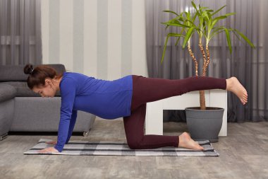 Motive güzel hamile anne rahat elbiseler giyer, bacaklar uzanan, sabah egzersizleri yapıyor, modern daire yalnız teşkil etmektedir, iyi esneklik gösterir. Fitness ve gebelik kavramı