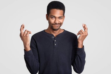 Hesiatnt belirsiz karanlık adam Çantalar dudaklar derili, parmak geçerek, mucize bekliyor, iyi şans için umuyor, yüz ifadesi, modelleri kapalı sıktı. İnsanlar, yüz ifadesi, beden dili