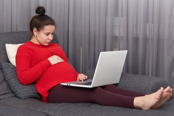 Foto Mujer Embarazada Siente Perezoso Mira Atentamente Computadora Portátil Posa — Foto de Stock