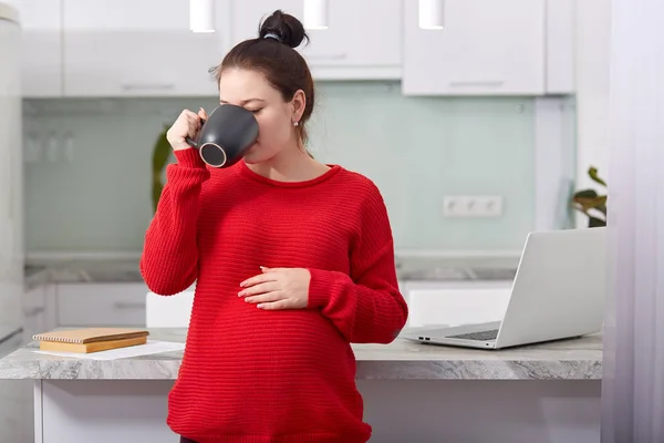Shot Pleasant Looking Woman Keeps Hand Tummy Drinks Hot Tea — Stock Photo, Image