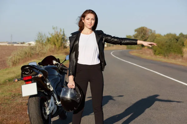 Buiten Schot Van Vrouwelijke Biker Hitchhikes Onderweg Helm Één Hand — Stockfoto