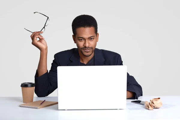 Foto Eines Ernstzunehmenden Dunkelhäutigen Mannes Arbeitet Freiberuflich Hält Die Brille — Stockfoto