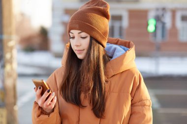 Çekici Bayan kullandığı cep telefonu gezinti bilinmeyen şehirde kullanımlar için online harita, moda giysiler giymiş, kullanır 4g ücretsiz internet, açık teşkil etmektedir. Kadının cep telefonu ile yatay görünüm
