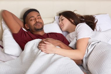İnsanlar, yatak zaman konsepti. Interracial sevgi çift yatakta sağlıklı uyku var, dinlenme keyfini çıkarın, iyi tadını çıkarın, yatak odasında poz. Afrikalı-Amerikalı genç adam nap beyaz karısı ile alır..
