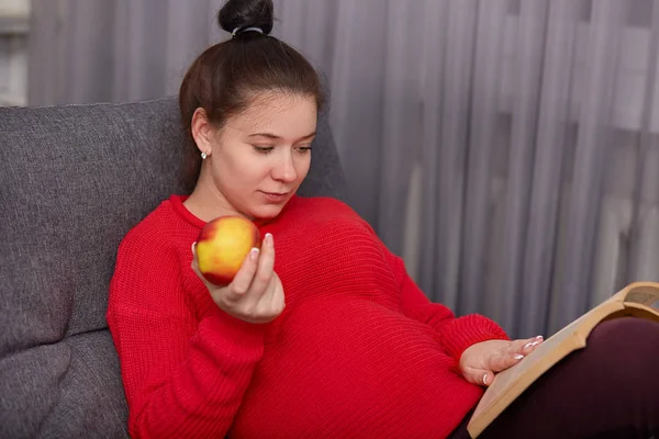 Embarazada Joven Madre Usa Suéter Rojo Tiene Moño Pelo Sostiene —  Fotos de Stock