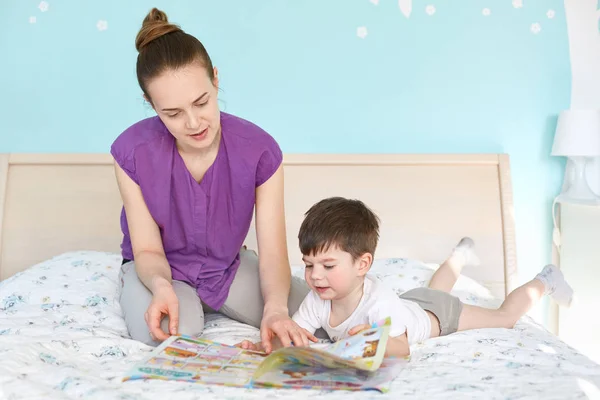 Caring Young Mother Reads Magazine Pictures Children Her Small Son — Stock Photo, Image