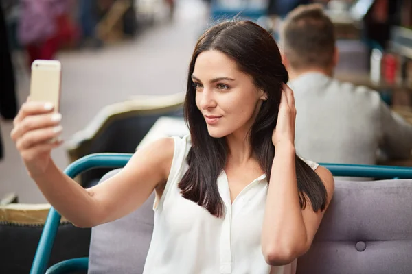 Photo Brunette Young Lady Takes Selfie Modern Cell Phone Dressed — Stock Photo, Image