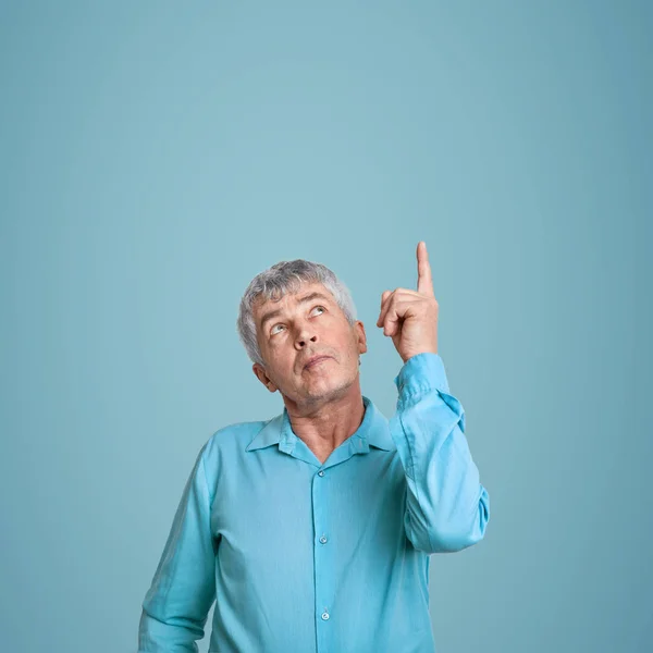 Indoor Shot Handsome Grey Haired Man Points Index Finger Wears — Fotografia de Stock