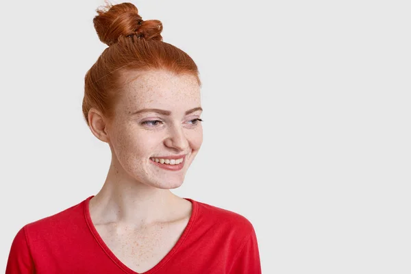 満足式 脇に焦点を当てて喜んでいる十代の少女の写真肯定的な見通しを持って快適な何かを考える 広告のための空白の白いスタジオの壁で分離された赤いジャンパーを着ています — ストック写真