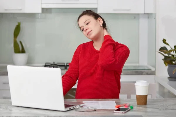 Photo Tired European Woman Keeps Hand Neck Works Freelance Laptop — Stock Photo, Image