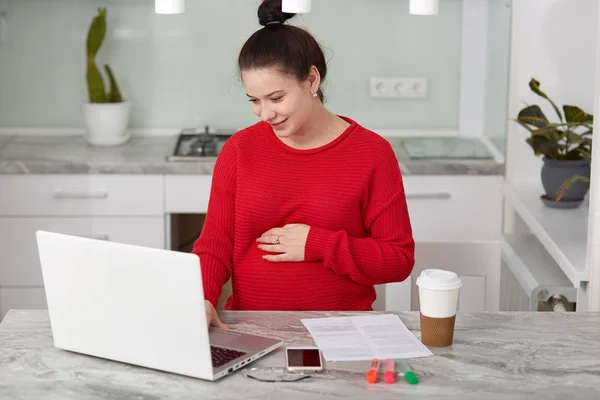 Positive Woman Anticipates Baby Keeps Hand Belly Wears Casual Clothes — Stock Photo, Image