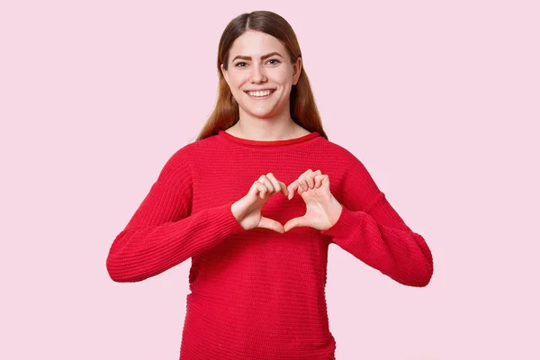 Happy Positive Brunette Woman Makes Heart Gesture Chest Dressed Red — Stok Foto