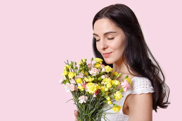 Image Attractive Woman Pleasant Look Closes Eyes Smells Flowers Celebrates — Stock Photo, Image