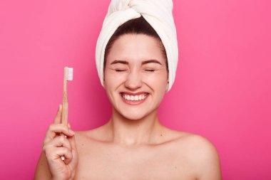 Yakın olumlu erkek atış kadar pürüzsüz bir cilt vardır, gözlerini kapa, gösterir beyaz dişler tutar, pozlar çıplak vücut ile başındaki beyaz havlu var, diş fırçası, diş, pink izole fırçalama için hazır tutar