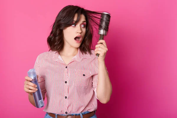 Hermosa mujer joven se siente asustada mientras sostiene laca para el cabello un —  Fotos de Stock