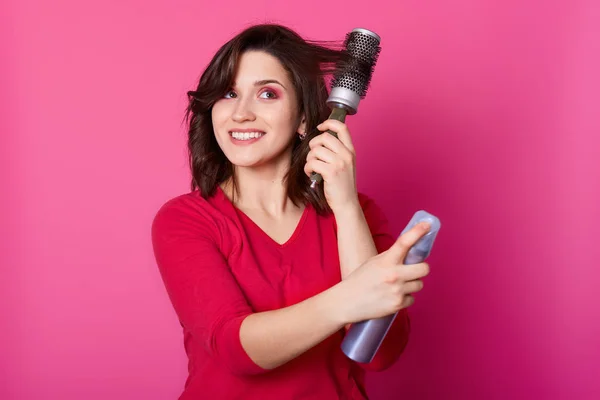 Mujer sonriente positiva con cabello castaño liso, utiliza laca para el cabello —  Fotos de Stock