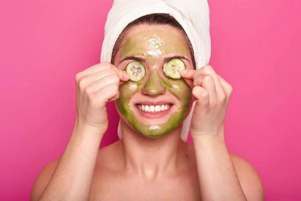 Imagen de mujer joven alegre tiene máscara verde en la cara, se aplica sl — Foto de Stock