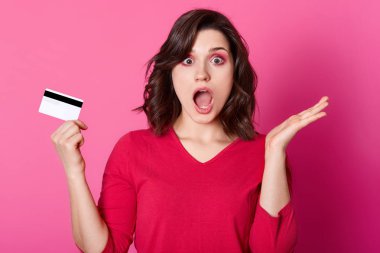 Şaşırmış gibi esmer kadının para sıkıntısı vardır yapmak için hiçbir fırsatı online satın almak. Genç erkek ile açılan ağız pembe duvarda izole sewater standları giyer. Interent ve alışveriş kavramı.