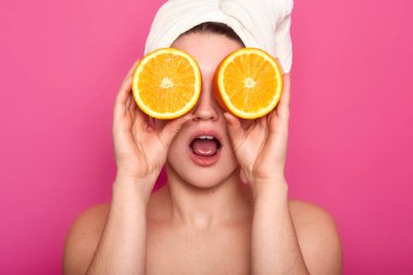 Stüdyo çekim hoş genç şok Avrupa kadın kapakları göz portakal ile beyaz havlu kafasına sahip arıyorum. Açık cilt pozlar pembe arka plan üzerinde izole Studio ile model. Güzellik kavramı.