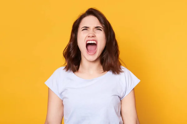 Gritando mujer enojada emocional posa isplated sobre studi amarillo — Foto de Stock