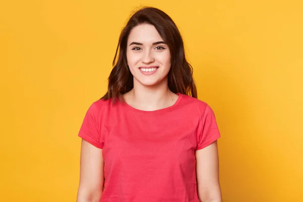 Ritratto ravvicinato di giovane donna che mostra sorriso, vestiti casual, isolato su sfondo giallo, essendo di buon umore, guarda direttamente alla fotocamera, ha una piacevole espressione facciale. Copia spazio . — Foto Stock