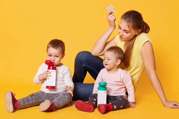 Una madre cariñosa positiva cuida a sus hijas gemelas, se sienta en el floo — Foto de Stock