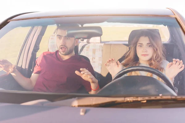 Image of beautiful woman at wheel learns to drive, her husband sits at front seat, young family look frightened, have some road block. Girlfriend and boyfriend spend time together. Traveling concept.