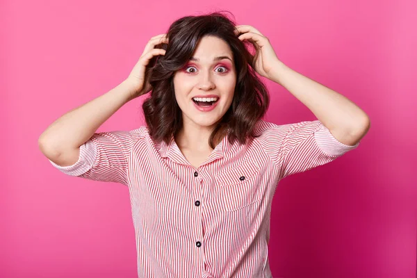 Primer plano retrato de una hermosa mujer morena cogida de la mano en la cabeza con sorpresa, mantiene los ojos y la boca ampliamente abiertos, con camisa desnuda, señora con expresión facial feliz. Concepto de movimientos humanos — Foto de Stock