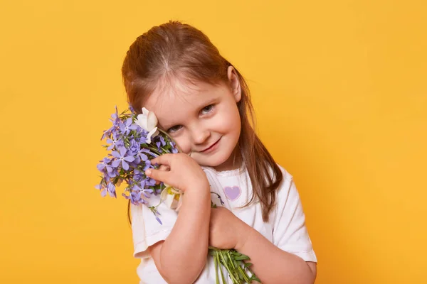 Gadis pemalu tapi cantik tersenyum mengenakan kemeja putih santai berdiri terisolasi di atas latar belakang studio kuning cerah, ingin mengucapkan selamat kepada ibunya dengan liburan. Selamat Hari Ibu! Konsep anak . — Stok Foto