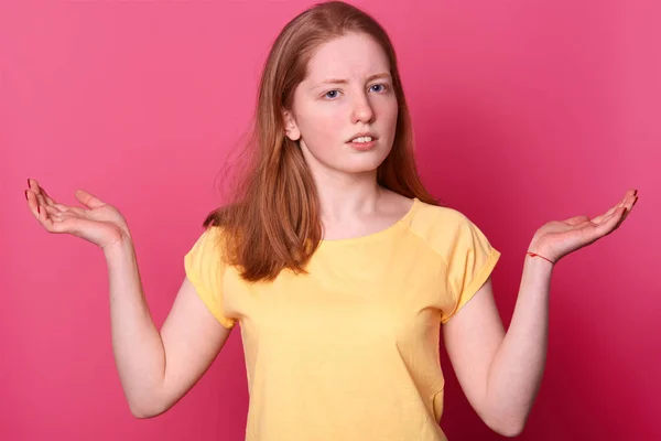 Sarı t shirt şaşkın tahriş şok genç kadın Portresi, düz kahverengi saçlı, fotoğraf stüdyosunda pembe arka plan izole elleri yayılıyor. İnsanlar samimi duygular, yaşam tarzı kavramı. — Stok fotoğraf