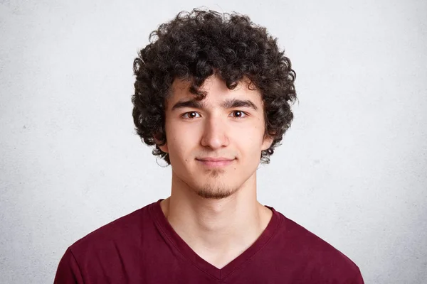 Close up retrato de encaracolado bonito macho europeu, vestindo camisa marrom casual, isolado sobre fundo branco, olhando diretamente para a câmera, beg fotografado em estúdio de fotografia. Conceito de pessoas . — Fotografia de Stock