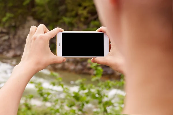 Frau macht Foto auf Smartphone, Dame mit Handy in der Hand, Reise-Bloggerin macht Video für Kanal, erstaunlicher Hintergrund. Nahaufnahme von Frauenhänden, die ein Handy mit leerem Kopierraum-Bildschirm halten. — Stockfoto