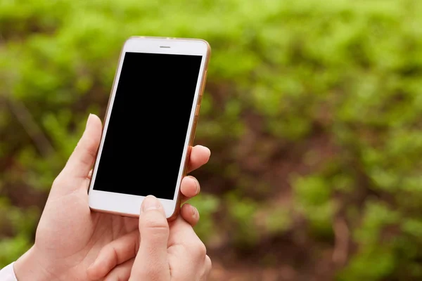 Hands of unknown holding modern device being around nature, black screen, turning off smartphone, no connection in forest, using mobile phone in everyday life, looking for way out with help of phone. — Stock Photo, Image