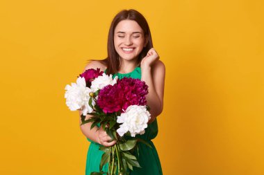 Mutlu esmer kız görüntü, gülümseyen ve beyaz ve Burgundy peonies buket tutan, mutluluğu ve mutluluğu ifade ediyor, tatil için hediye var, heyecanlı görünüyor. İnsanlar duygular kavramı.