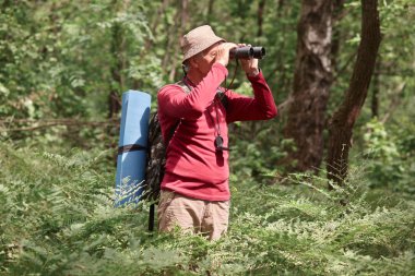 Aktif hırçın dürbün ile seyir profili, boynuna pusula sahip, Sweatshirt ve pantolon giyiyor, Backpacker ve onunla uyku Pad alarak, kamp gidiyor. Aktivite konsepti.