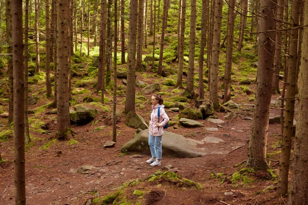 Venku je ta mladá dívka, která chodí v lese sama, Žena v těsné bundě, která šťastně chodí, je mezi stromy a ráda tráví čas v čerstvém vzduchu. Cestování, dobrodružství, aktivní hlasová koncepce. — Stock fotografie