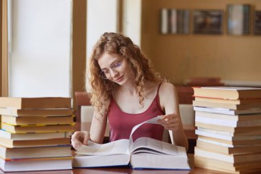 Eğitim, lise, üniversite, öğrenme ve insan kavramı. Kütüphanede kitap okuyan öğrenci kız kapalı çekim, sınava hazırlanıyor, yararlı bilgiler bulmak, tilki saçlı kadın.