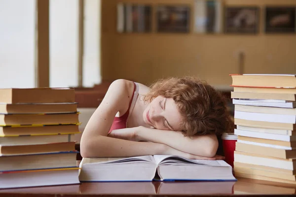 室内拍摄的疲惫的学生睡在书上，在复红室，精疲力竭的学习，睡着了，而阅读辅导材料的类。教育、知识与考试理念. — 图库照片