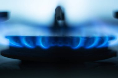 Gaz ocağı yanan yakın resim, gaz ocak metalik özel yuvarlak etrafında bulunan parlak mavi alevler, açık mavi arka plan, yangın en az eşit yanan sahip. Gaz ekonomisi kavramı.