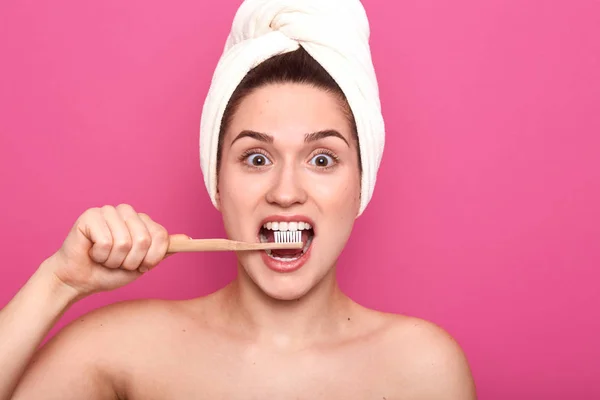 Imagen de una divertida hembra magnética sosteniendo su cepillo de dientes de madera en la cavidad, haciendo el procedimiento diario, disfrutando del proceso, cuidando su salud, abriendo sus ojos ampliamente con emoción. Concepto dental . — Foto de Stock