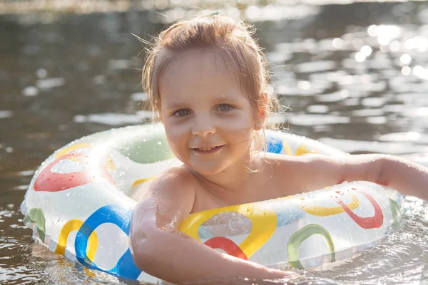 풍선 반지와 함께 물에서 재생 귀여운 백인 아이 소녀, 재미와 행복과 여름 시간을 보내고, 아이는 행복한 얼굴 표정으로 카메라를 직접보고. 어린 시절 개념. — 스톡 사진
