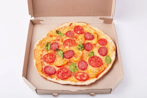 Image of fresh tasty pizza in cardboard box on white surface, picture of fast food dish, supper from restaurant or cafe. Fast food eating concept. Open box with delicious pepperoni pizza on table. — Stock Photo, Image